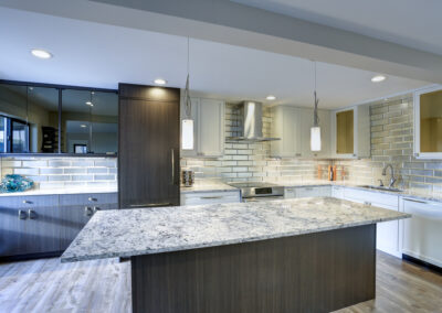 Well appointed kitchen features a large kitchen island, gray quartzite countertops, silver backsplash and white shaker cabinets. Advantage Stone Fabrication in Longmont, Mead and Frederick Colorado.